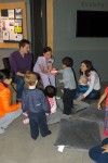 A female Wesbrook Village Dentist show kids how to brush properly