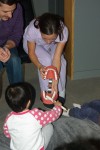 A female Wesbrook Village Dentist show kids how to brush properly